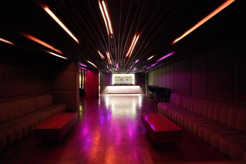 a room with red and purple lights and benches at Heaven Prestige Hotel in Jounieh