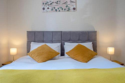 a bedroom with a bed with two yellow pillows at Cosy Northumbrian Cottage in Barrasford