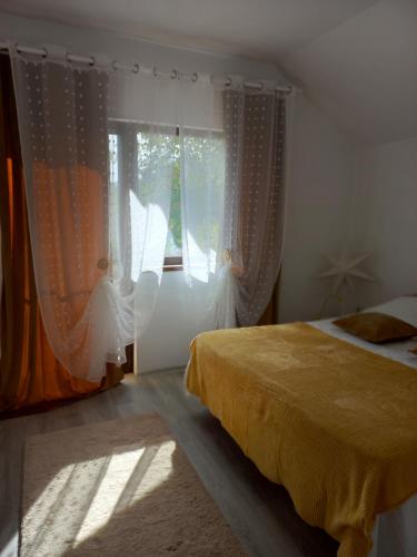 a bedroom with a bed and a window with curtains at Cabana Cami in Iaşi