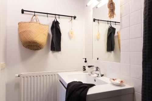 een witte badkamer met een wastafel en een spiegel bij Voel je thuis in Zwolle