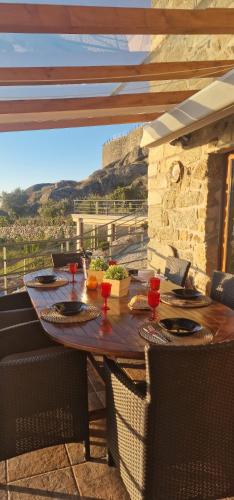 a wooden table with chairs and food on a patio at Casa do Penedo Castle House in Linhares