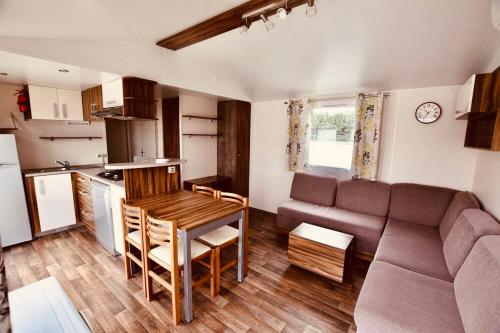 Il dispose d'une cuisine et d'un salon avec une table et un canapé. dans l'établissement Les Pierres Couchées 4 étoiles à St Brévin les Pins emplacement BR22 3CH 2SDB 8 personnes, à Saint-Brévin-les-Pins