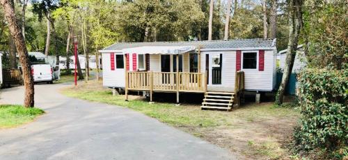 Cette petite maison rouge et blanche dispose d'une terrasse couverte. dans l'établissement Les Pierres Couchées 4 étoiles à St Brévin les Pins emplacement BR22 3CH 2SDB 8 personnes, à Saint-Brévin-les-Pins