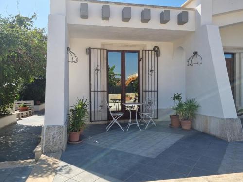 a white house with a patio with plants at Casa Sbrizza in Rosolini