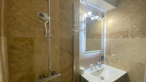 La salle de bains est pourvue d'une douche avec un lavabo et un pommeau de douche. dans l'établissement Appartement dans résidence les jardins de Neptune saint cyprien plage,piscine, jeux enfants, à Saint-Cyprien