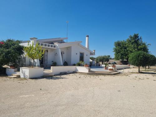 a white house with a lot of plants and trees at Casa Sbrizza in Rosolini