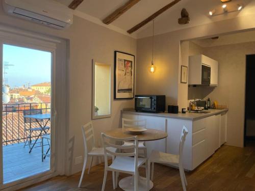 eine Küche mit einem Tisch und Stühlen sowie einen Balkon in der Unterkunft Romantic attic room with panoramic view in Bologna