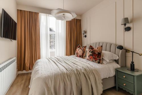 a white bedroom with a bed and a window at Biskey Howe- Georgian Charm in Bowness-on-Windermere