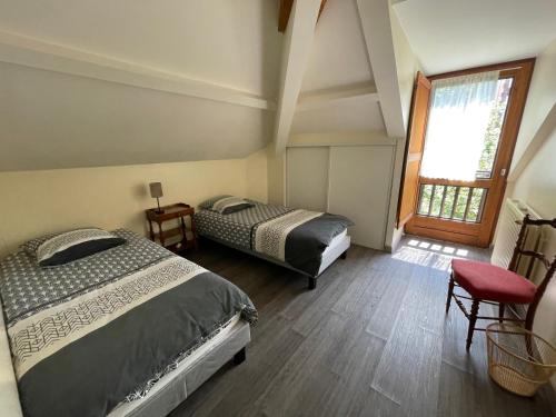 a bedroom with two beds and a window at VILLA BONVOULOIR in Bagnères-de-Bigorre