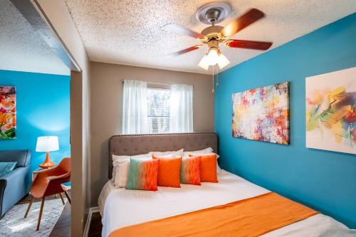 een slaapkamer met blauwe muren en een bed met kleurrijke kussens bij Entire Place King Bed Washer Dryer Fast WiFi 2 Cars #509 in Fort Worth