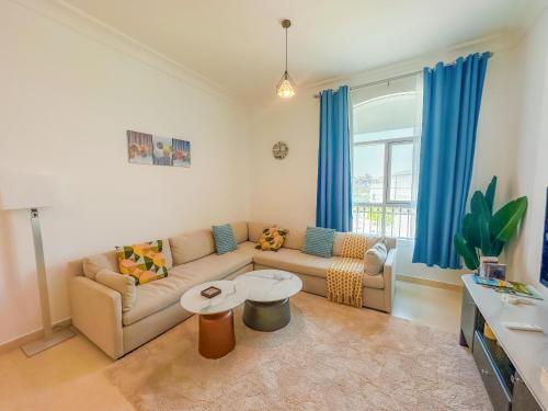 ein Wohnzimmer mit Sofa und blauen Vorhängen in der Unterkunft Dreams & Themes Ansam Yas Island 108A3 in Abu Dhabi