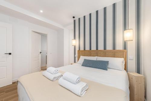a bedroom with a large white bed with towels on it at BNBHolder Best I Madrid Rio in Madrid