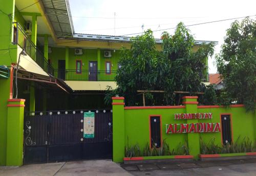 una casa verde con un cancello nero e una recinzione di Wisma Almadina Syariah a Jepara