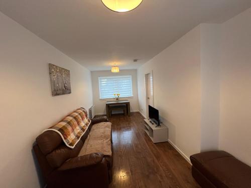 a living room with a couch and a table at The Wee Hoose Rhu in Rhu