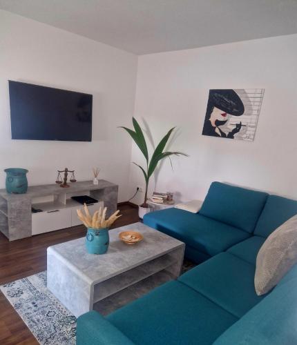 salon z niebieską kanapą i telewizorem w obiekcie Detmolder Perle w mieście Detmold