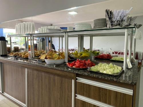 a buffet with fruits and vegetables on a counter at Nasser Hotel Aeroporto in Núcleo Bandeirante