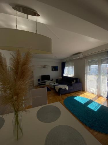 un soggiorno con divano e tappeto blu di CocoLux a Loznica