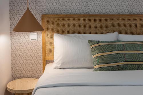 a bed with a wooden headboard and two pillows at BNBHolder Best II Madrid Rio in Madrid