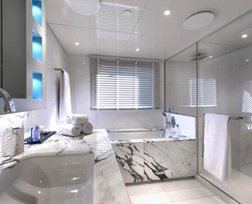 y baño blanco con bañera y ducha. en Thai Yacht, en Ban Bo Thong