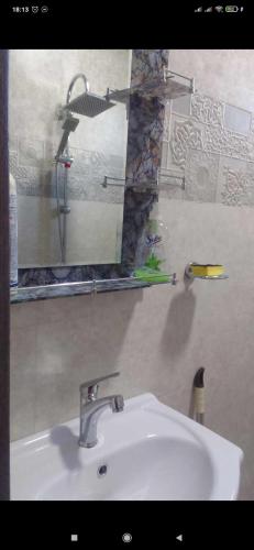 lavabo blanco en el baño con espejo en GuestHouse Oni-Li, en Oni