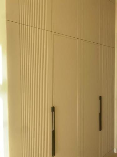une armoire blanche avec poignées noires à côté d'une fenêtre dans l'établissement Aktau Riviera, 1 bedroom apartment, à Ömirzaq
