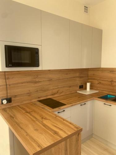 - une cuisine avec un comptoir en bois et un four micro-ondes dans l'établissement Aktau Riviera, 1 bedroom apartment, à Ömirzaq