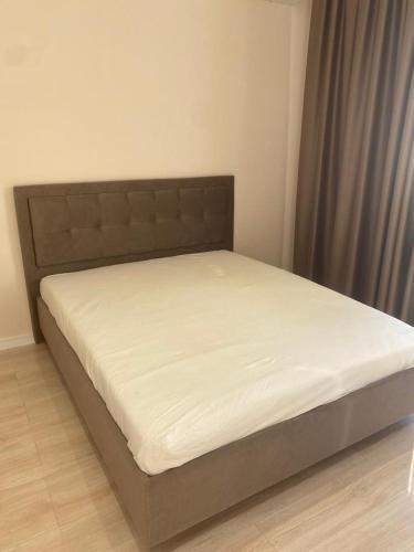 Ce lit se trouve dans une chambre dotée d'un matelas blanc. dans l'établissement Aktau Riviera, 1 bedroom apartment, à Ömirzaq