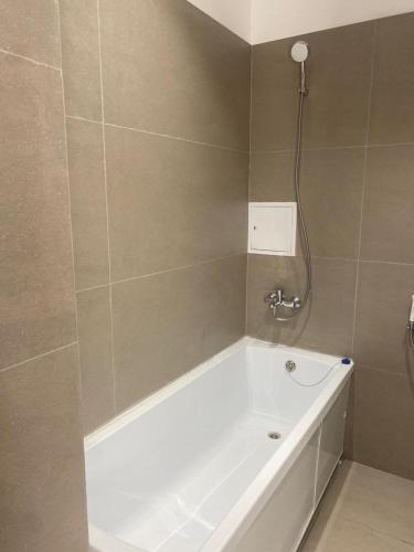 La salle de bains est pourvue d'une baignoire et d'une douche. dans l'établissement Aktau Riviera, 1 bedroom apartment, à Ömirzaq