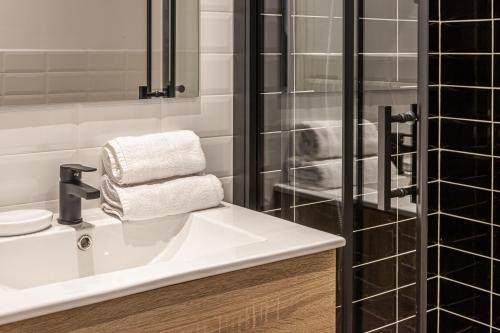 ein Badezimmer mit einem weißen Waschbecken und einer Dusche in der Unterkunft BNBHolder Best III Madrid Rio in Madrid