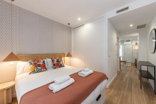 um quarto com uma cama grande e toalhas em BNBHolder Best III Madrid Rio em Madri