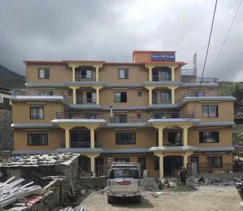 a yellow building with a truck parked in front of it at Hotel Grand Shambala in Muktināth