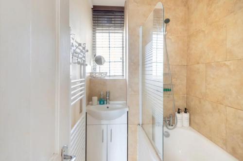 y baño con ducha, lavabo y bañera. en Stunning 1 bed flat in the heart of Greenwich, en Londres