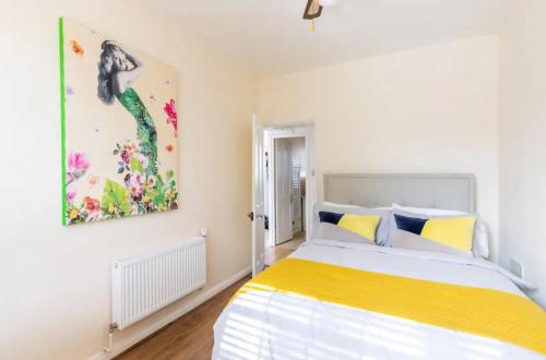 a bedroom with a bed and a painting on the wall at Stunning 1 bed flat in the heart of Greenwich in London