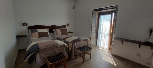 two beds in a room with a window at B & B Giu & Dany in Bruscoli