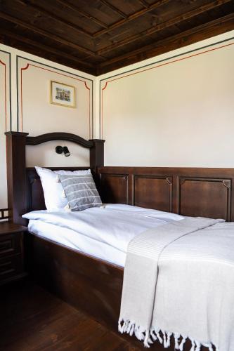 a bedroom with a large bed with a wooden headboard at Къща ЕТНО in Koprivshtitsa