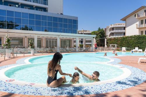 eine Familie spielt im Pool in der Unterkunft Hermitage Hotel in Silvi Marina