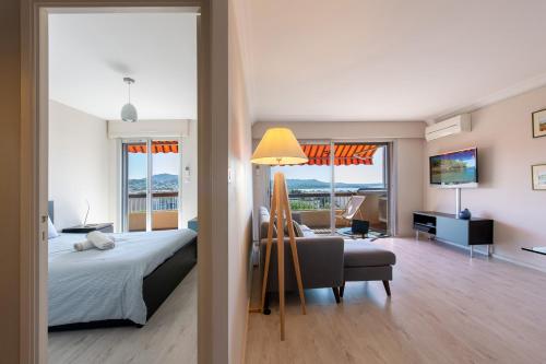 une chambre avec un lit et un salon dans l'établissement le Cadet - vue panoramique ville et baie de SANARY SUR MER, parking & terrasse - 2 à 4 pers, à Sanary-sur-Mer