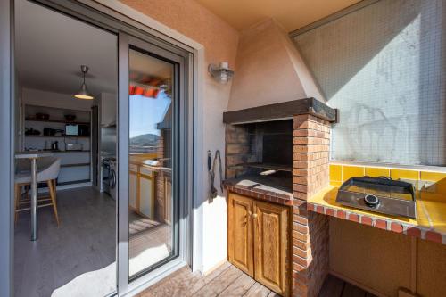 une petite cuisine avec un évier et une cuisinière dans l'établissement le Cadet - vue panoramique ville et baie de SANARY SUR MER, parking & terrasse - 2 à 4 pers, à Sanary-sur-Mer