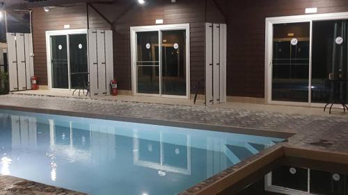 a swimming pool in front of a house at Lovely Paradise Phangan Hotel in Thongsala