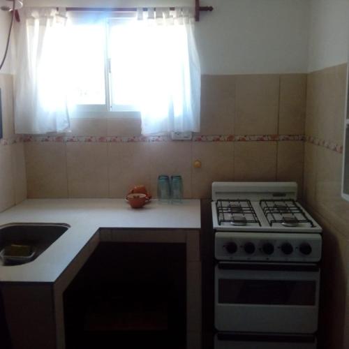 a small kitchen with a stove and a sink at los jacarandaes in San Isidro