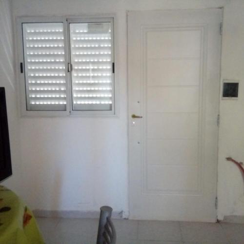 Una puerta blanca en una habitación con ventana en los jacarandaes en San Isidro