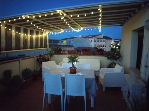 a patio with a table and chairs and lights at Terraced paradise in Alghero