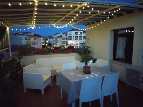 a white table and chairs in a patio with lights at Terraced paradise in Alghero