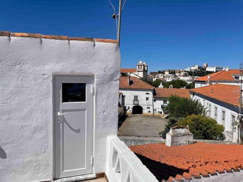 una puerta blanca en el lateral de un edificio blanco en Casa Velha Estremoz, en Estremoz