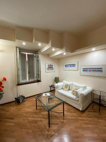 a living room with a white couch and a glass table at PM 2 Via Scano Guest House A in Sassari