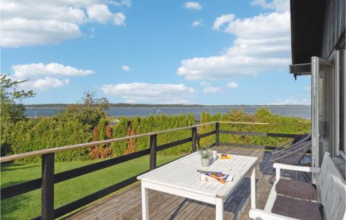 a white table on a deck with a view of the water at 2 Bedroom Nice Home In Jægerspris in Jægerspris