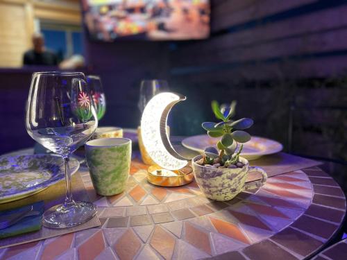 a table topped with plates and a wine glass and a cactus at Le stanze di chiara in Torre Lapillo