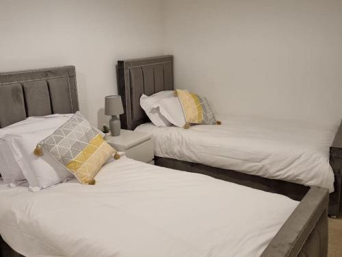 two beds sitting next to each other in a bedroom at Modern 2bedroom House in Ipswich Suffolk in Ipswich
