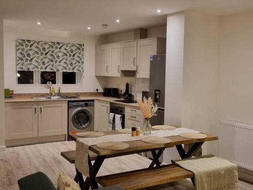 Modern 2bedroom House in Ipswich Suffolk في إبسويتش: مطبخ مع طاولة خشبية في مطبخ