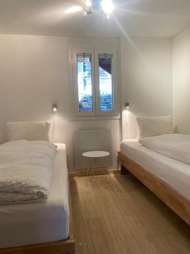 - une chambre avec 2 lits, une table et 2 fenêtres dans l'établissement am Bärgbach 1.OG, à Bettmeralp